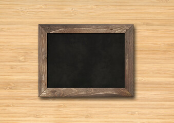 Old rustic black board isolated on a wooden background