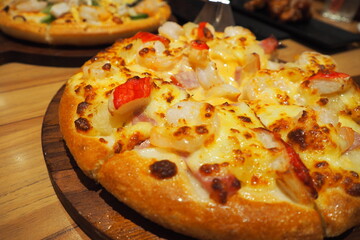 Delicious and colorful freshly baked pizza served on wooden tray for food sharing concept