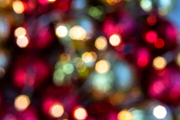 Obraz premium Gold and red bokeh abstract background with defocused lights and Christmas balls.