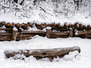 The wooden fences in the park are covered with beautiful fluffy snow. Winter in the city, selective focus.