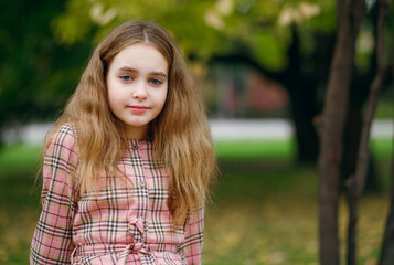 Portrait of a child girl against the background of the Green City Park