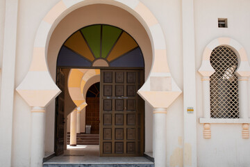A door of a mosque with a window next to it