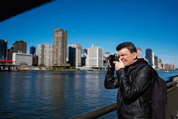 Portrait Latino man taking photos on the banks of the Hudson River in New York