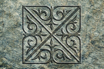 Ornamental print on the stone surface. Vintage ornament on the stone. Close-up seamless texture. Stone texture. Pattern on the stone. Embossed pattern. Wallpaper.