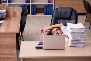 Young male employee unhappy with excessive work in the office