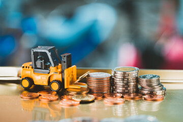 Closeup stack coins with forklift vehicle using as business and logistics industry concept © jaturonoofer