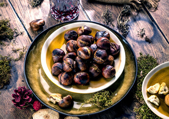 Roasted chestnuts for Christmas served on a wooden table with red mulled wine