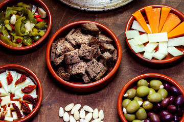 Set of tapas appetizers prepared at home in ceramic bowls.