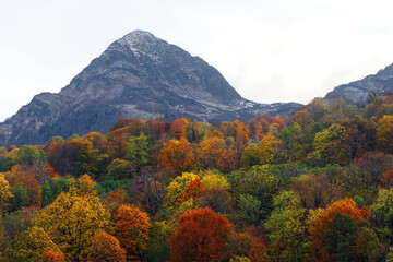  autumn forest on the slope of the Aibga mountain range and the Black Pyramid peak in cloudy weather