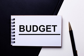 BUDGET written in red on a black and white background near the pen