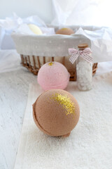 Spa concept with bath bombs and sea salt bottle on lights background. Beauty wellness, body care...