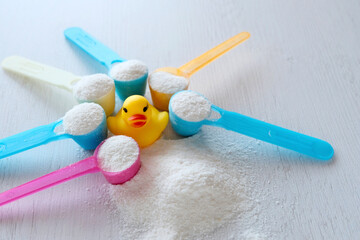 Blue plastic spoon with powder, infant formula, flour. Close-up. Dairy cuisine concept. Healthy food for early infants.