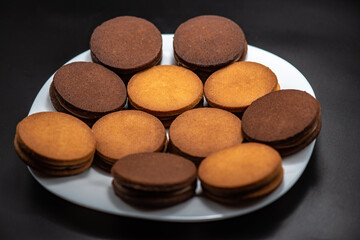 Round roast with chocolate in confectionery on a black background