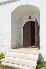 An old wooden door in the white fortress wall