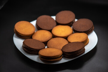 Round roast with chocolate in confectionery on a black background