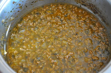 Stir fried mince beef. Cooking minced beef in a stainless steel frying pan. Bolognese ragout in skillet, top view.