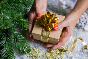 
beautiful festive surprise box gift golden with a bow girl holding in her hands near the christmas...