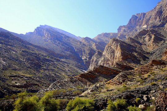Mountains with unidirectional rocks fractures and grass area, Wadi Bani Awf, Al Rustaq, South Batinah Governorate of Oman