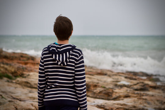 Teenage boy staring out to sea