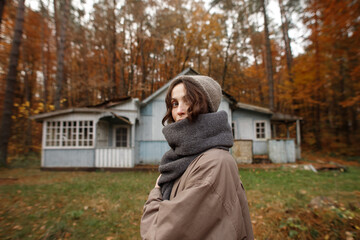 young woman in the autumn forest near the old house