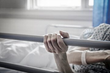 Dłonie starszej osoby na łóżku szpitalnym - obrazy, fototapety, plakaty
