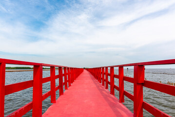 Samut Sakhon, Thailand - October 23 ,2020 : Perspective Low angle view at the wooden Red Boardwalk bridge viewpoint of sea in Mueang Samut Sakhon District, Thailand
