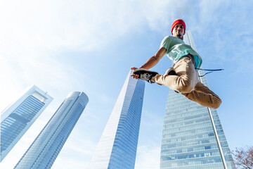 Close-up of a young man practicing break dance and jumping between skyscrapers