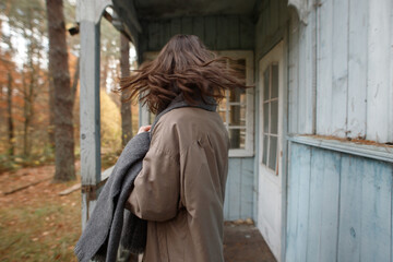 young woman in the autumn forest near the old house