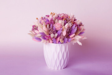Mixed colorful dry flower bouquet in pink and violet colors in vase. Modern style in the interior.