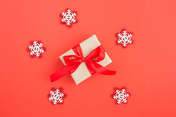 Top view of Christmas gift and decorative snowflakes  on the red background
