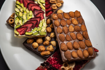 Chocolate bar with the addition of fruit nuts on background. Dessert food concept.
