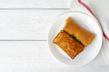 Two fried russian pancakes on white wooden table