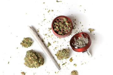 Flat lay view of a cannabis branch, joint and red grinder isolated in a white background. Marijuana legalization. Medical cannabis. Drug addiction.	