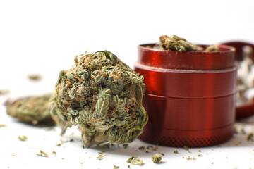Cannabis branch, joint and red grinder isolated in a white background. Marijuana legalization. Medical cannabis. Drug addiction.	