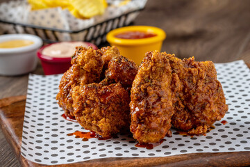 Baked chicken wings with sesame and sauce on wooden background