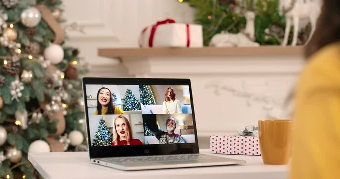 Close up of laptop screen with multiple online call between joyful females and ild man talking and sending xmas congratulation on Xmas. Caucasian and Asian people videochatting on New Year. Close up