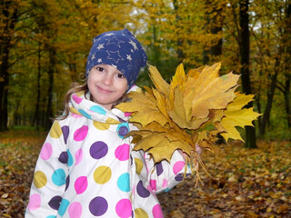 Girl with a bouquet of yellow autumn maple leaves in the park. - 395078932