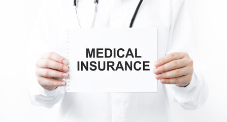 Doctor holding a card with text MEDICAL INSURANCE, medical concept