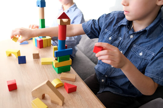 children, boys builds towers and buildings from colored wooden figures, the concept of housing construction, mortgage, insurance, happy childhood, children's games, alpha generation