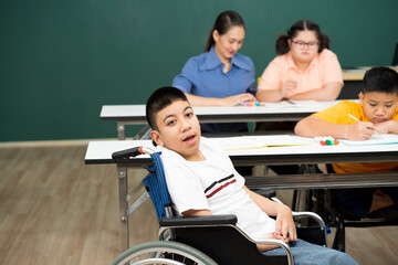 disability boy sitting on wheelchair in classroom special with teacher and AUtism kids education