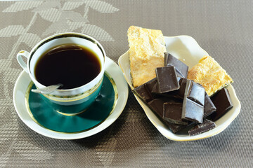 Cup of tea chocolate and cake on the table.