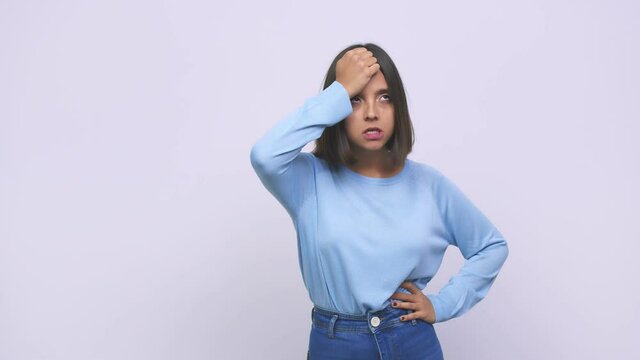 Young mixed race woman forgetting something, slapping forehead with palm and closing eyes