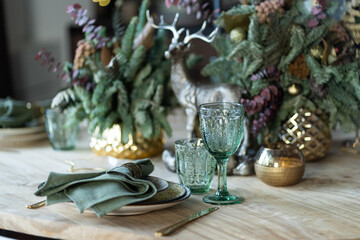 Festive table setting for the new year and christmas. Beautiful decorations, dishes, candles. Quiet family dinner during self-isolation due to covid.
