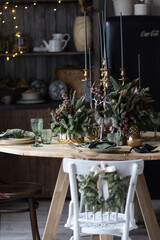 Festive table setting for the new year and christmas. Beautiful decorations, dishes, candles. Quiet family dinner during self-isolation due to covid.