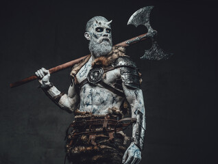 Risen from the dead king with pale skin and horns dressed in dark armour in twilight with hatchet...