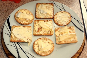 Crackerbread biscuits with spreadable cheese on a plate