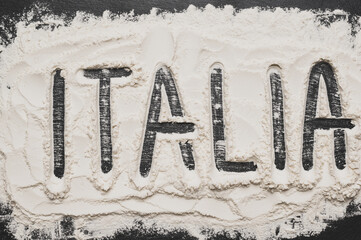 Italia sign with flour Artwork With Food And Handprints, Fun background with human handpints in scattered flour on the dark background. Copy space