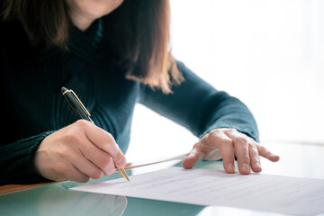 Woman in shirt signing docu