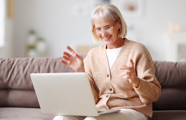 Content mature woman having video call on laptop.
