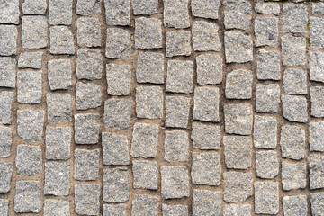 Stone cobble pattern on a street or pavement, grey granite material texture